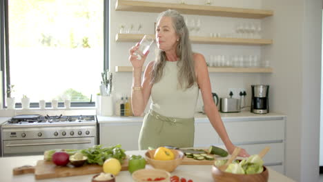 A-mature-Caucasian-woman-drinking-water-in-kitchen