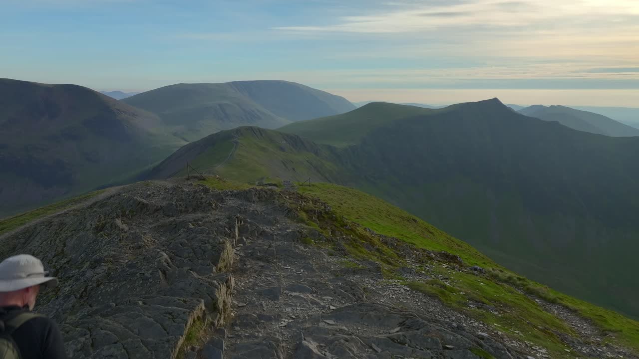 산악 산책자 가 산꼭대기 에 도착 하면서 험난 한 실루 을 가진 봉우리 와 산맥 을 볼 수 있다