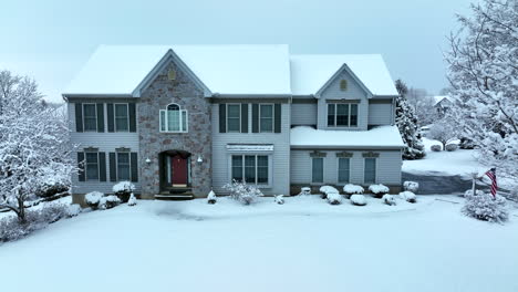 American-flag-at-traditional-two-story-home-in-fresh-winter-snow