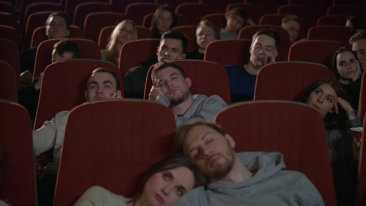 público aburrido viendo una película en el cine. los espectadores se quedan dormidos de una película aburrida
