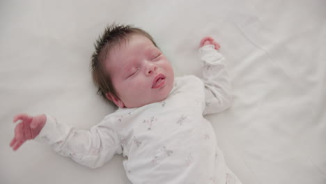 newborn, face or sleeping with stretching on bed