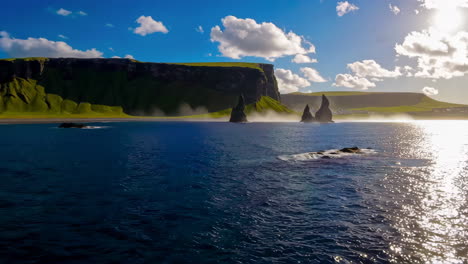 dramatic coastal landscape with towering sea stacks and sunlit ocean