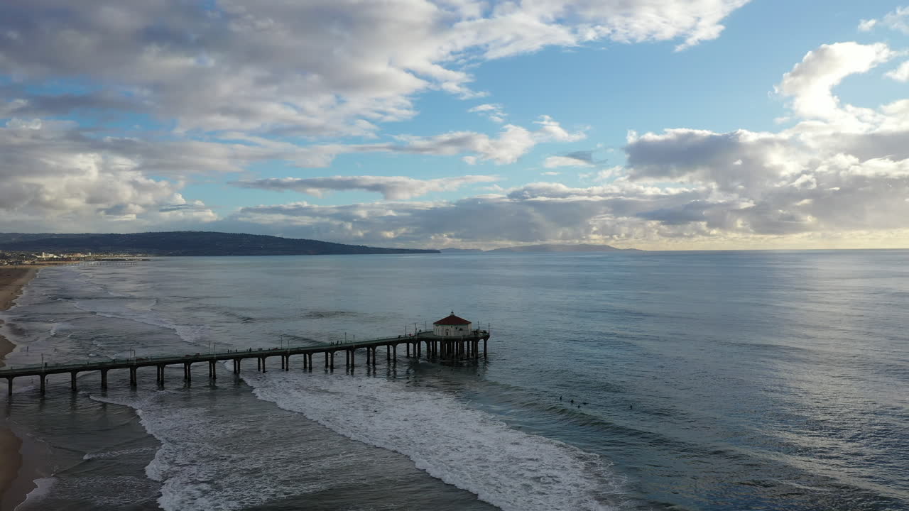 Drone che vola sopra un tramonto nuvoloso a Manhattan Beach, California