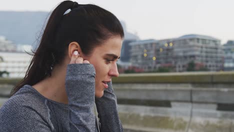 young woman listening to music before running