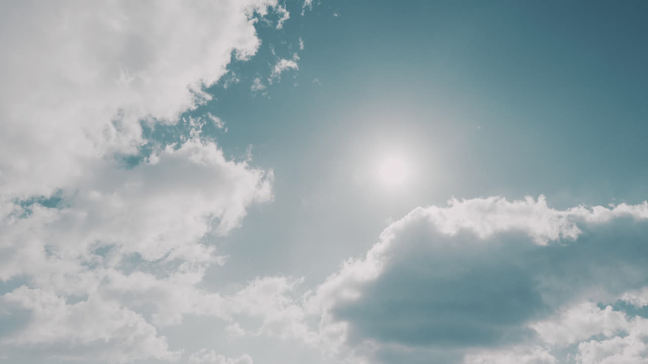 Clouds move on pale blue winter sky on sunny day, timelapse