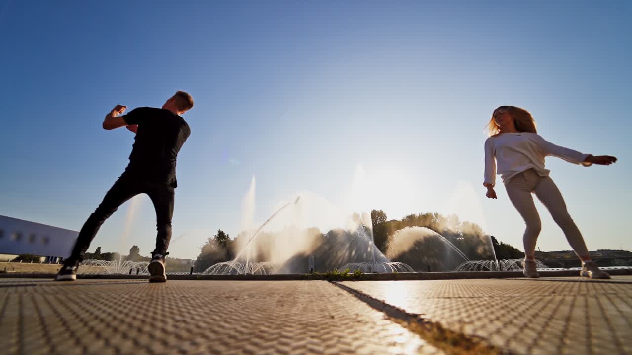 Couple of lovers dancing on street. Romantic young couple dancing outdoors near fountain