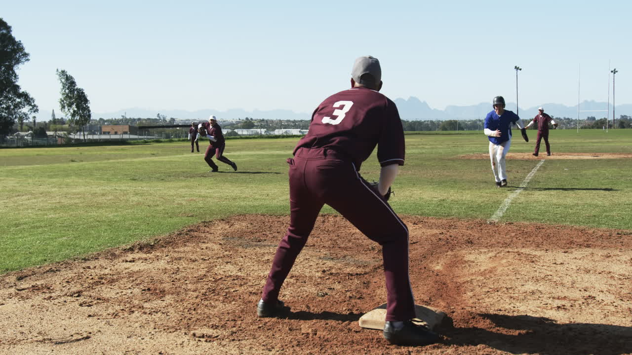 Multiracial male baseball players, throwing and catching ball, running on a pitch, slow motion