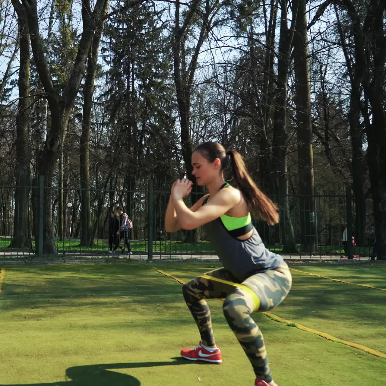 Athletic woman working out at the stadium using rubber bands. Working out hard. Lifestyle sport.