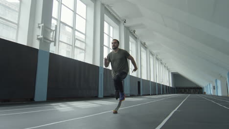 man with prosthetic limb running in stadium