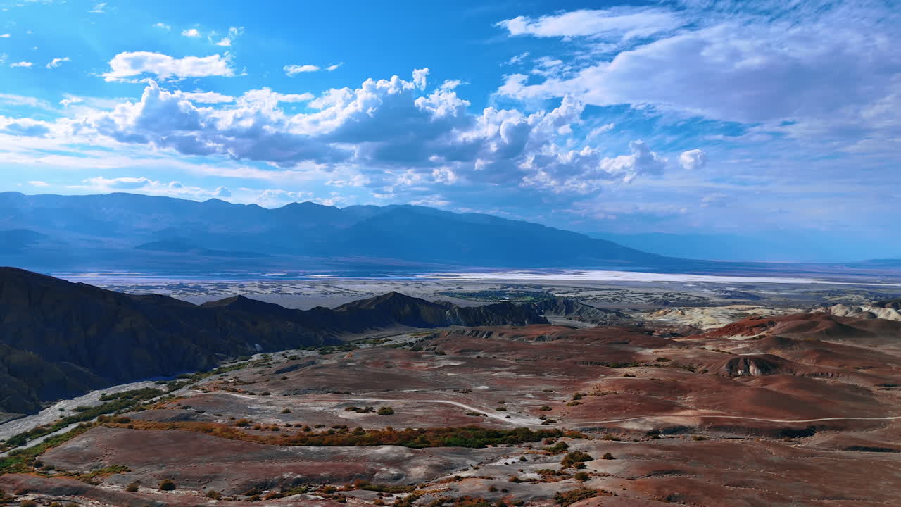 Iconic view on the stunning Death Valley National Park, California, USA. Beautiful fluffy clouds in the azure sky above the scenery. Aerial perspective