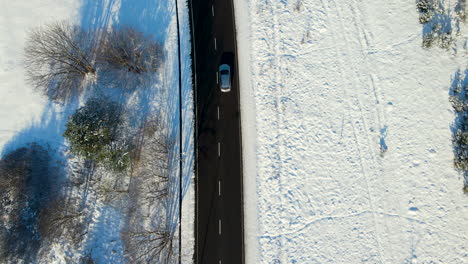 mutlple cars driving over a two lanes road cleared from snow in a winter wonderland near gdansk poland on a sunny day