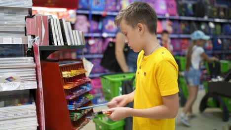 boy preparing for september. portrait view of boy with shopping cart