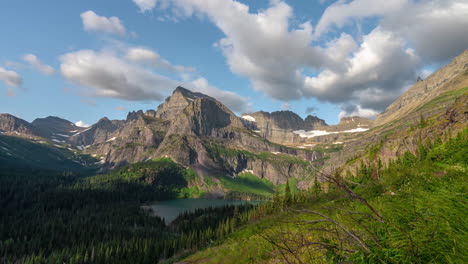 timelapse, heavenly mountain landscape on sunny summer day, clouds and shadows on green valley with lake under hills and peaks