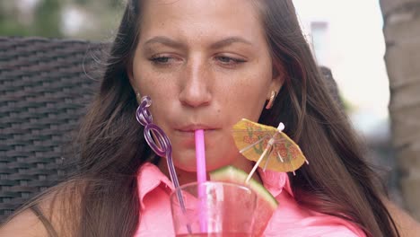 happy-woman-with-loose-hair-tastes-cocktail-and-smiles