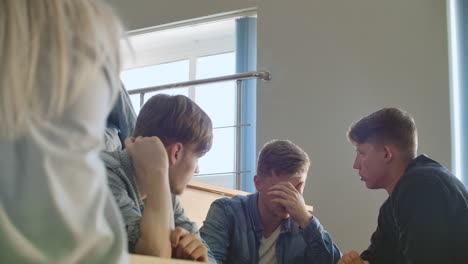 el grupo de estudiantes alegres y felices sentados en una sala de conferencias antes de la lección.