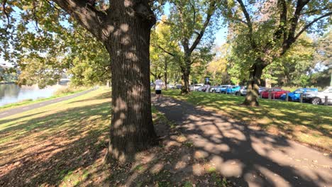 person walking along a riverside park path