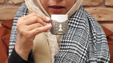 woman drinking coffee outdoors