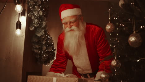 santa claus brings gifts under the christmas tree for children. give gifts to children on christmas night. santa puts a gift under the christmas tree. high quality 4k footage