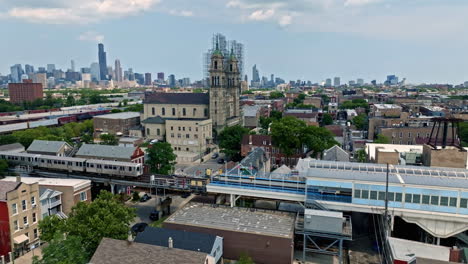 aerial view of the pink line cta train arriving at the 18th station, in pilsen, chicago