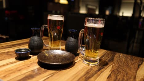 beer glasses and sake set on wooden table