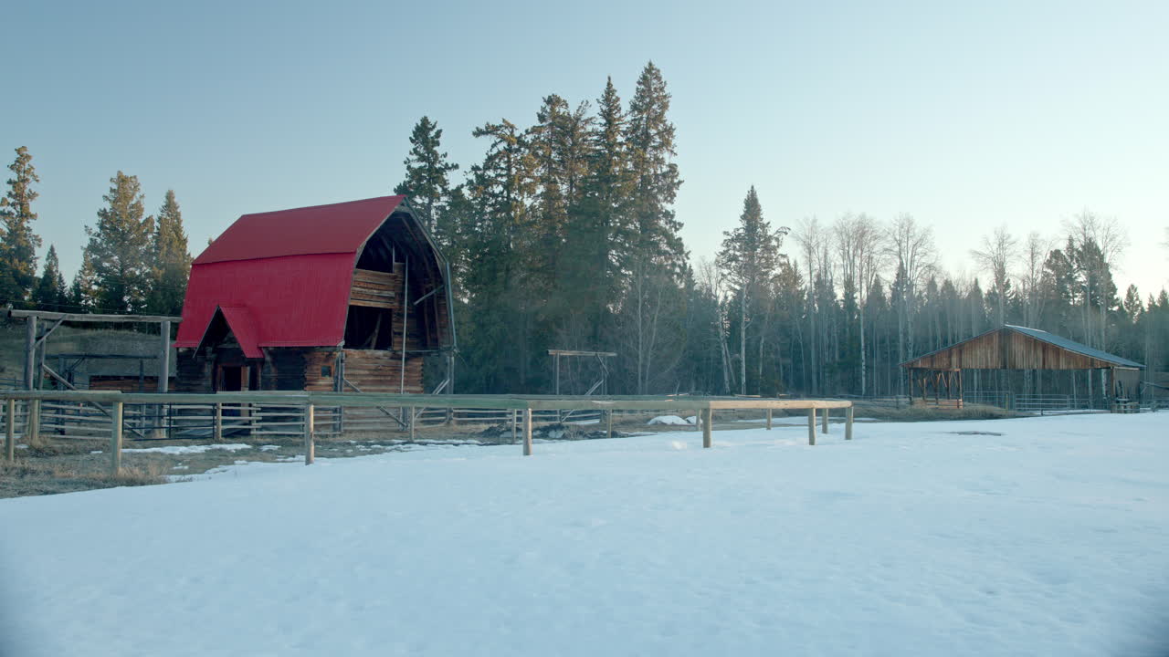 Perfekt rød lade stående på en frossen mark ved solopgang.