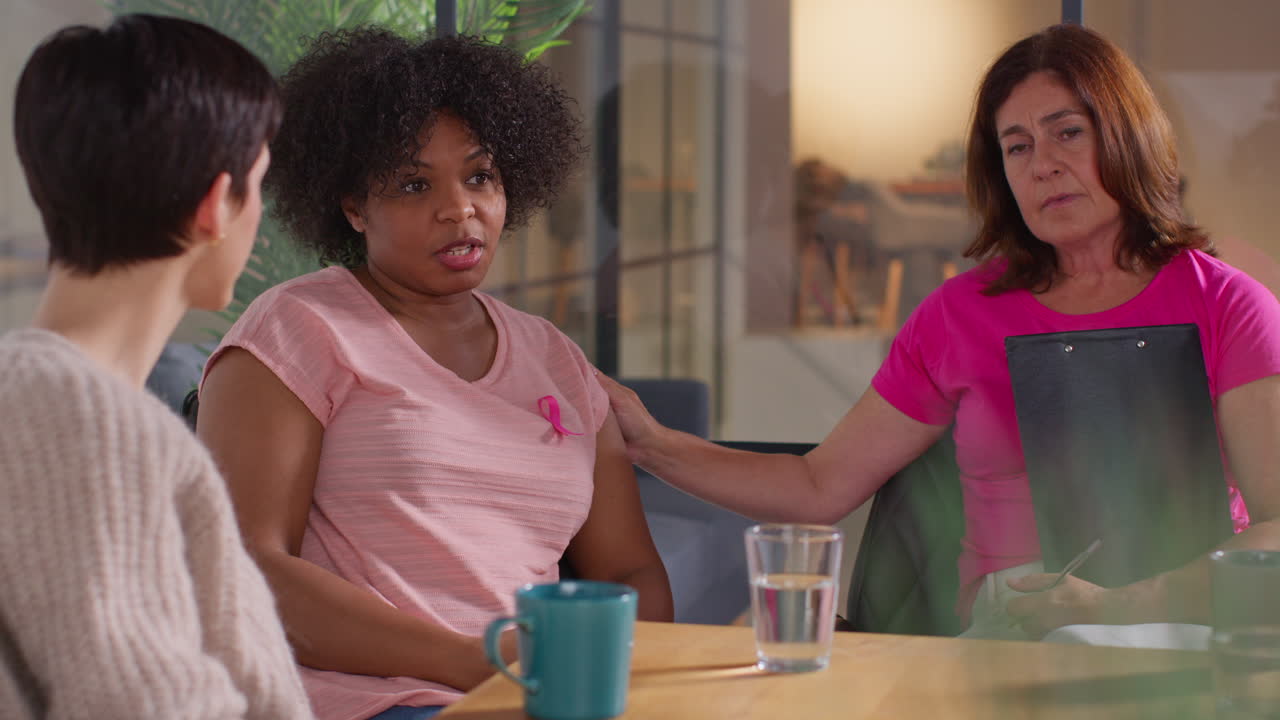 grupo de mujeres que llevan cintas rosas de concienciación sobre el cáncer de mama se reúnen y hablan en el grupo de apoyo a la terapia para pacientes con tratamiento de cáncer 10