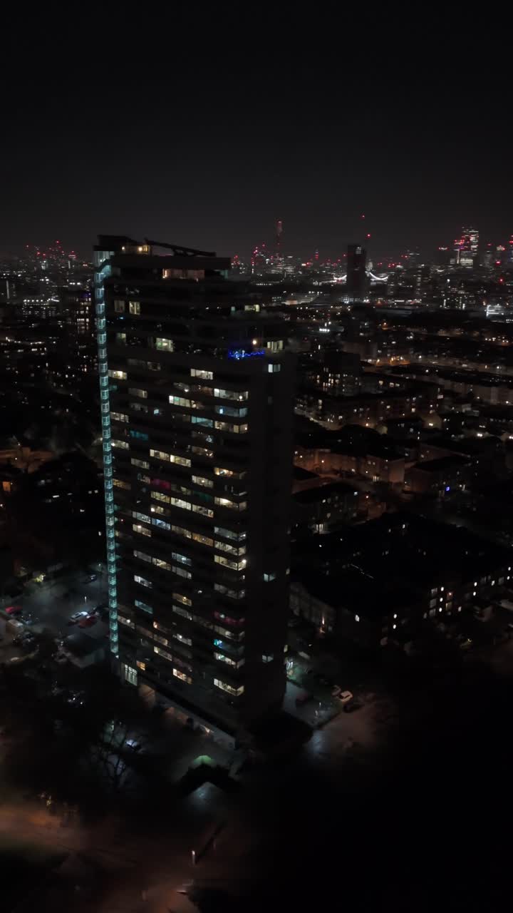 Vertical drone shot of a condo tower and the Deptford cityscape, night in London