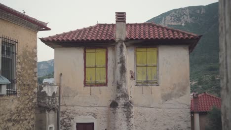 static view of boarded up windows in mediterranean town old building, leonidio greece