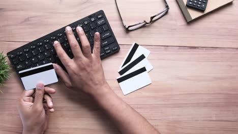 person using credit card and keyboard