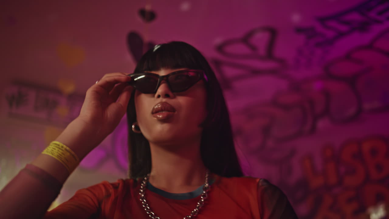 Chic brunette dancing club in sunglasses closeup. woman moving body in bar