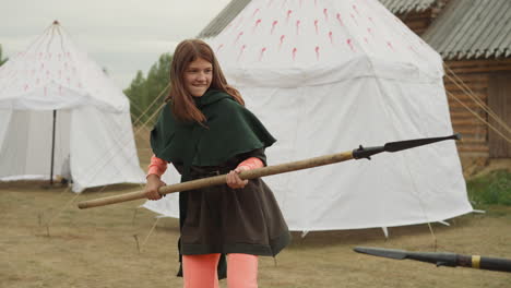 smiling teenage girl and young man train to fight on spears