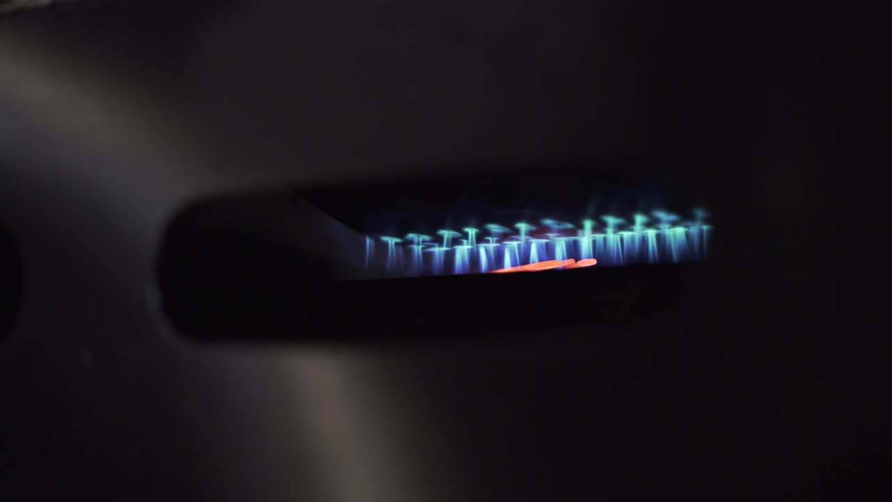 로스터 실린더 아래의 불 오븐에서 불타는 파란 불꽃