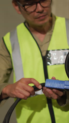 asian male worker wearing safety suit with helmet in warehouse