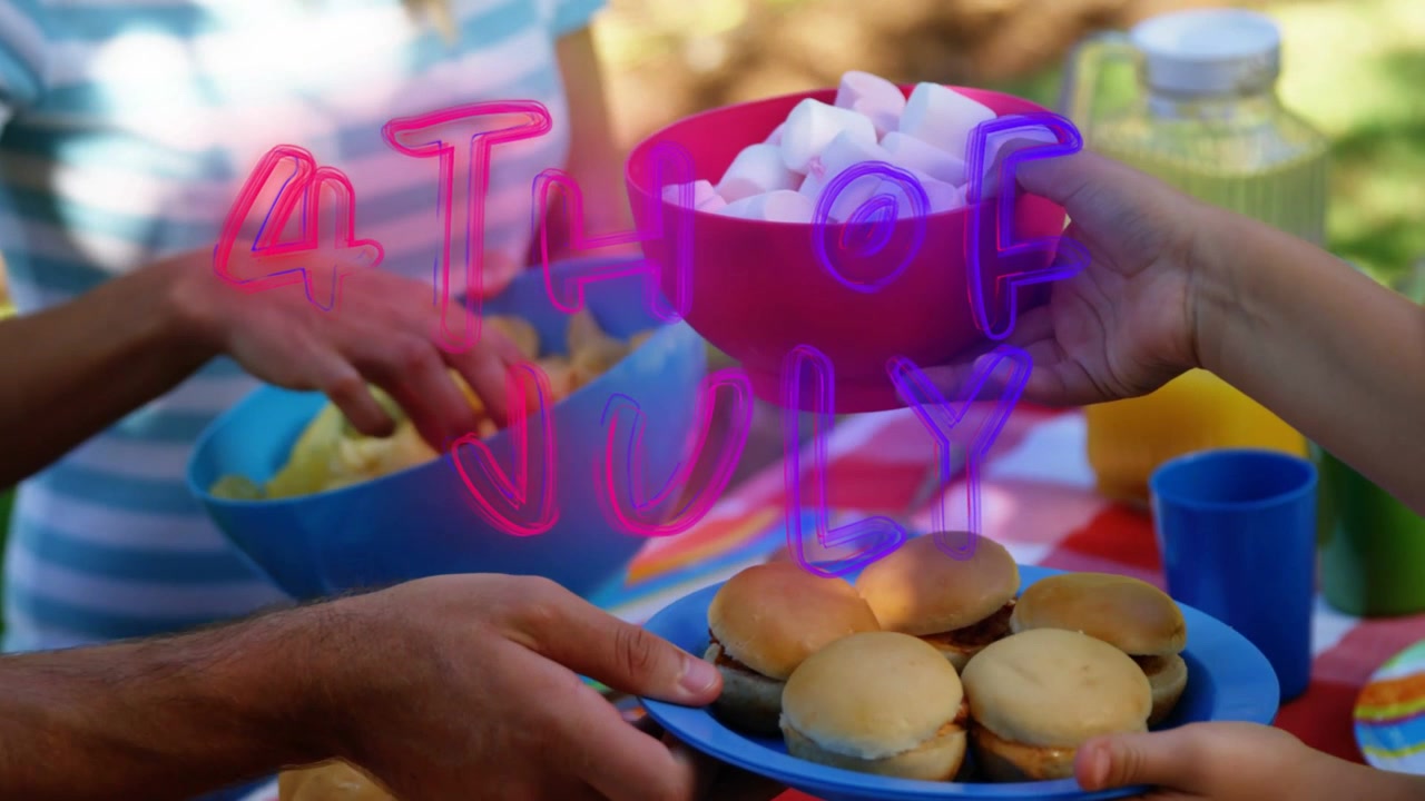 Piatto blu di mini-hamburger che viene presentato e passa di mano in mano, celebrando un picnic del 4 luglio.