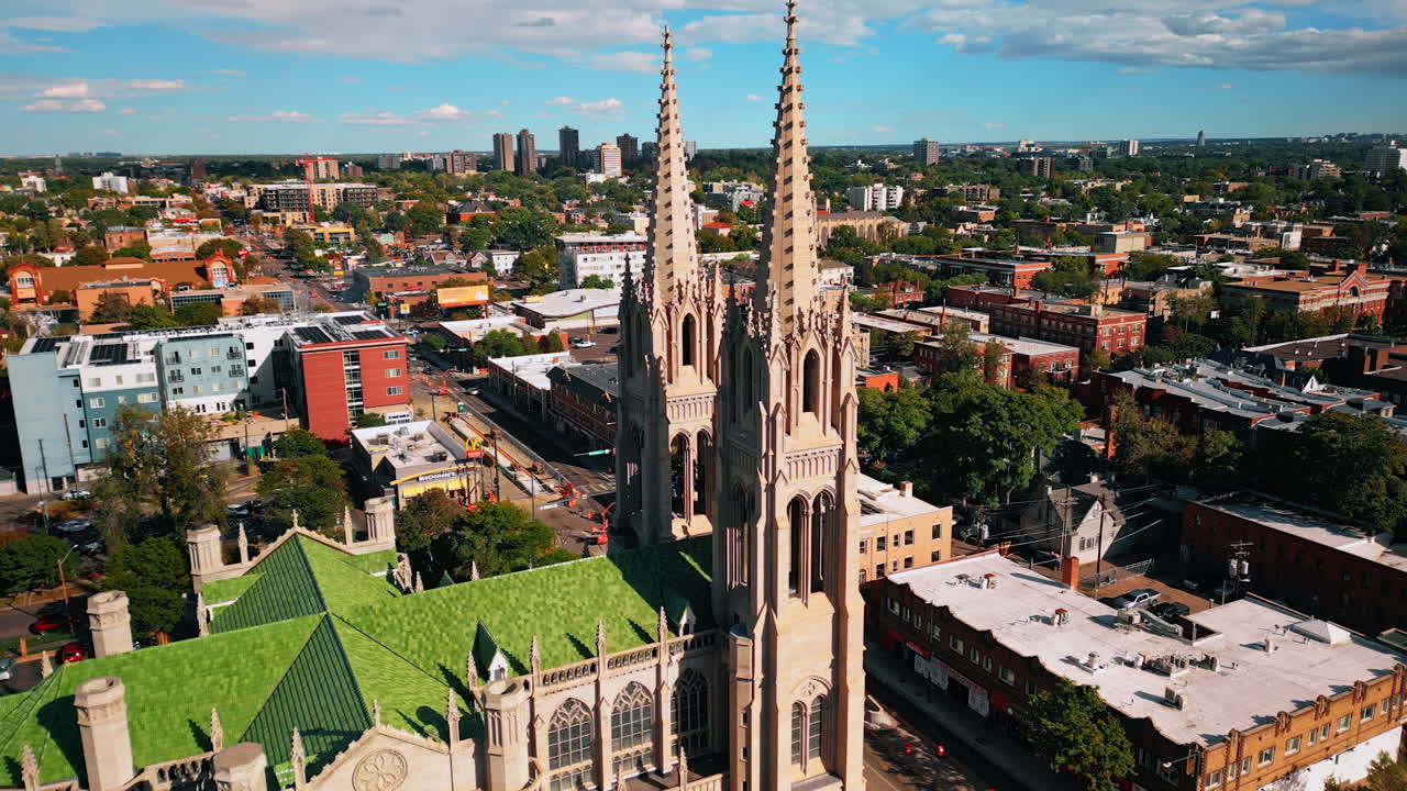 Denver, USA, 24 August 2025: Marvelous towers of the Cathedral Basilica of the Immaculate Conception in Denver, Colorado, USA. Beautiful green cityscape at backdrop from drone on sunny day