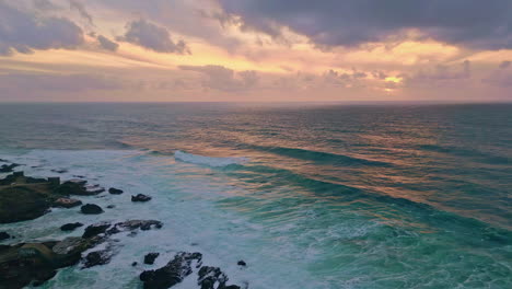 ocean surface reflecting golden evening light drone view. sea waves crashing