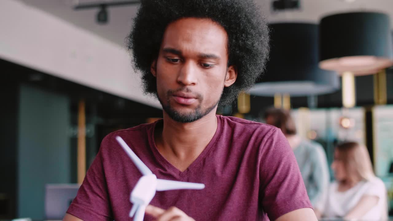 African man with model of wind turbine