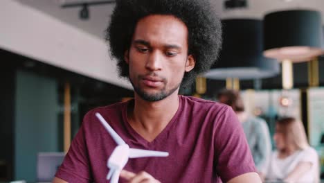 african man with model of wind turbine