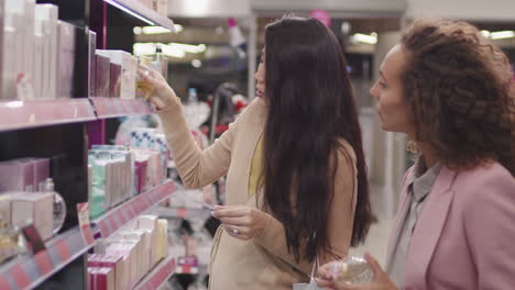 Girlfriends Testing Perfumes From Blotters In Cosmetics Store