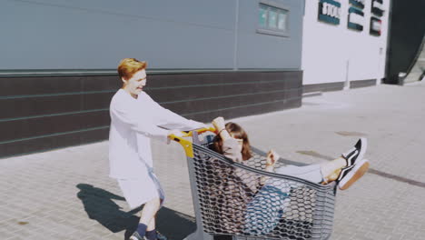 amigos divirtiéndose con un carrito de compras