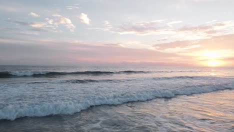 Aerial-sliding-shot-over-the-white-foaming-surf-of-the-pacific-ocean-on-the-beach-of-playa-bandera-in-costa-rica