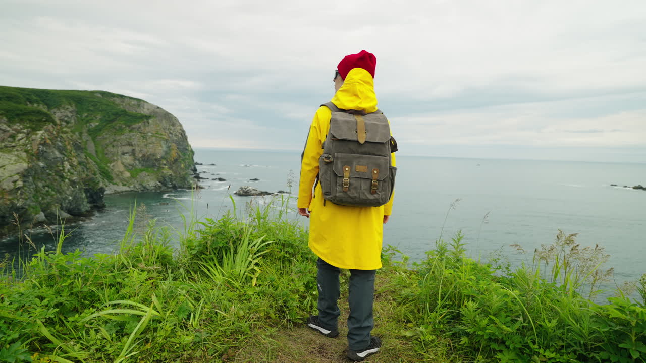 mujer caminando por un acantilado costero