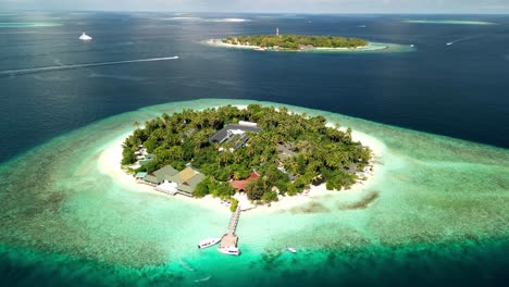 paraíso de la isla tropical - malahini kuda bandos, maldivas: avión no tripulado girar en sentido contrario a las agujas del reloj desde lo alto, bandos telón de fondo desde el muelle