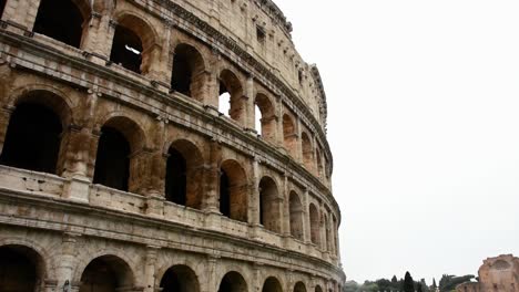 the colosseum in the center of the city of rome, just east of the roman forum