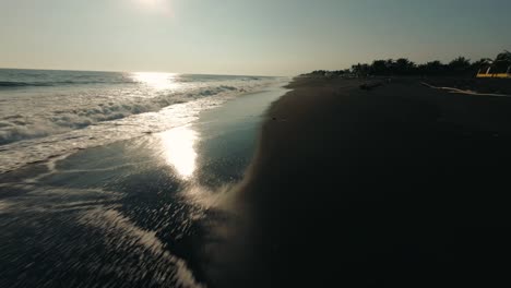 fast fly over playa de monterrico with splashing waves during dusk in guatemala
