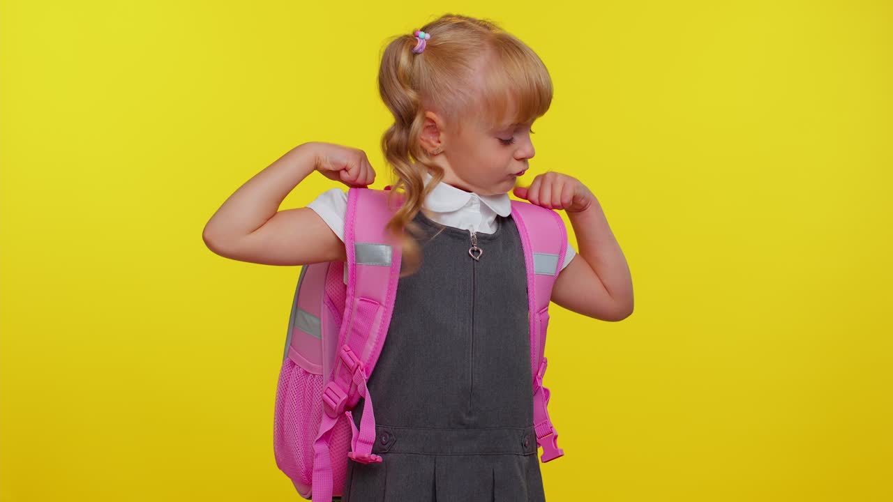 encantadora niña segura niña niña en uniforme escolar mostrando bíceps, sintiendo fuerza fuerza para el estudio