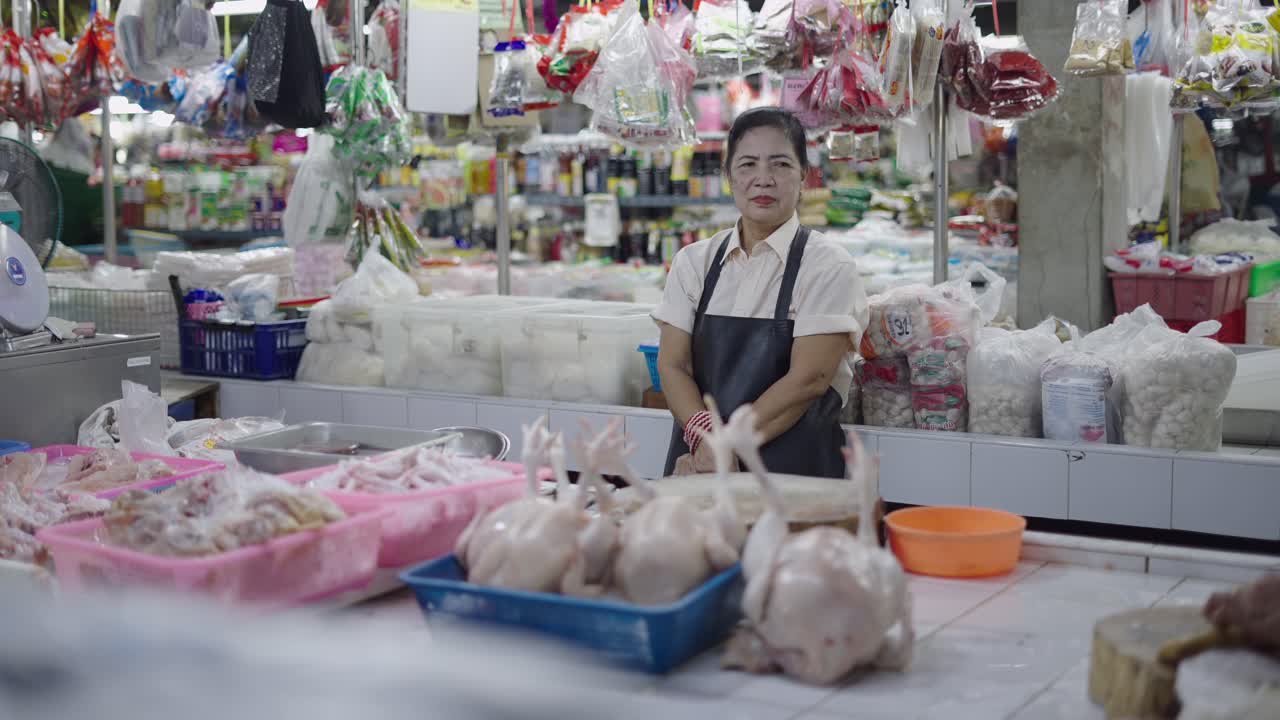 Woman standing in front of fresh chicken in a market