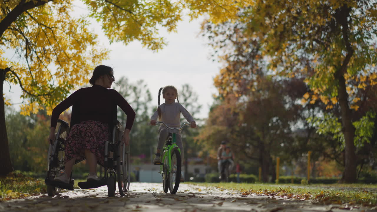 ⁇ 체어 에 있는 젊은 이모 와 자전거 에 타고 있는 조카 가 공원 에서 휴식을 취하고 있다