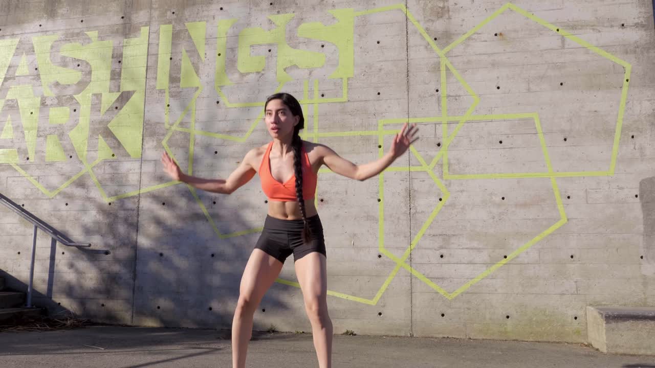 mujer joven haciendo rutina de ejercicios de burpee mientras hace ejercicio afuera.