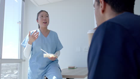 Un-Joven-Trabajador-Sanitario-Asiático-Conversa-Con-Un-Colega-Durante-Un-Descanso-En-El-Hospital.